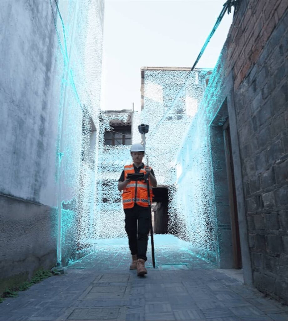 Arpentage 3D LiDAR : collecter un nuage de points dans une ruelle. Géomètre en gilet de sécurité et casque blanc, effectuant un arpentage 3D mobile dans une ruelle. Les murs affichent un nuage de points LiDAR bleu.